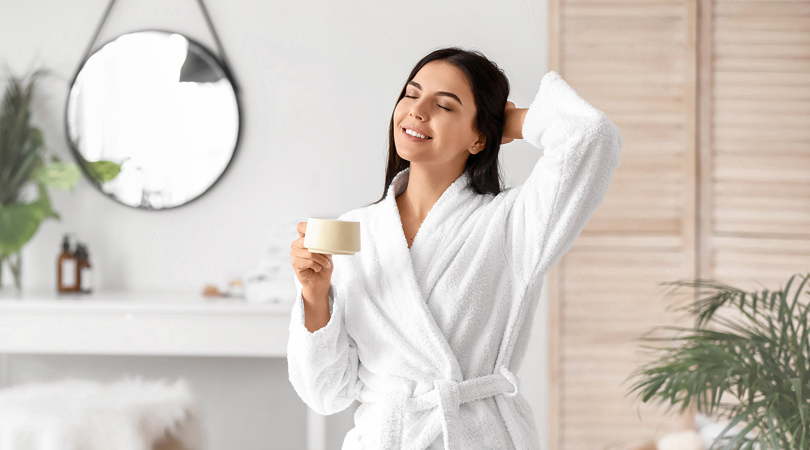 Young woman drinking coffee in bathroom