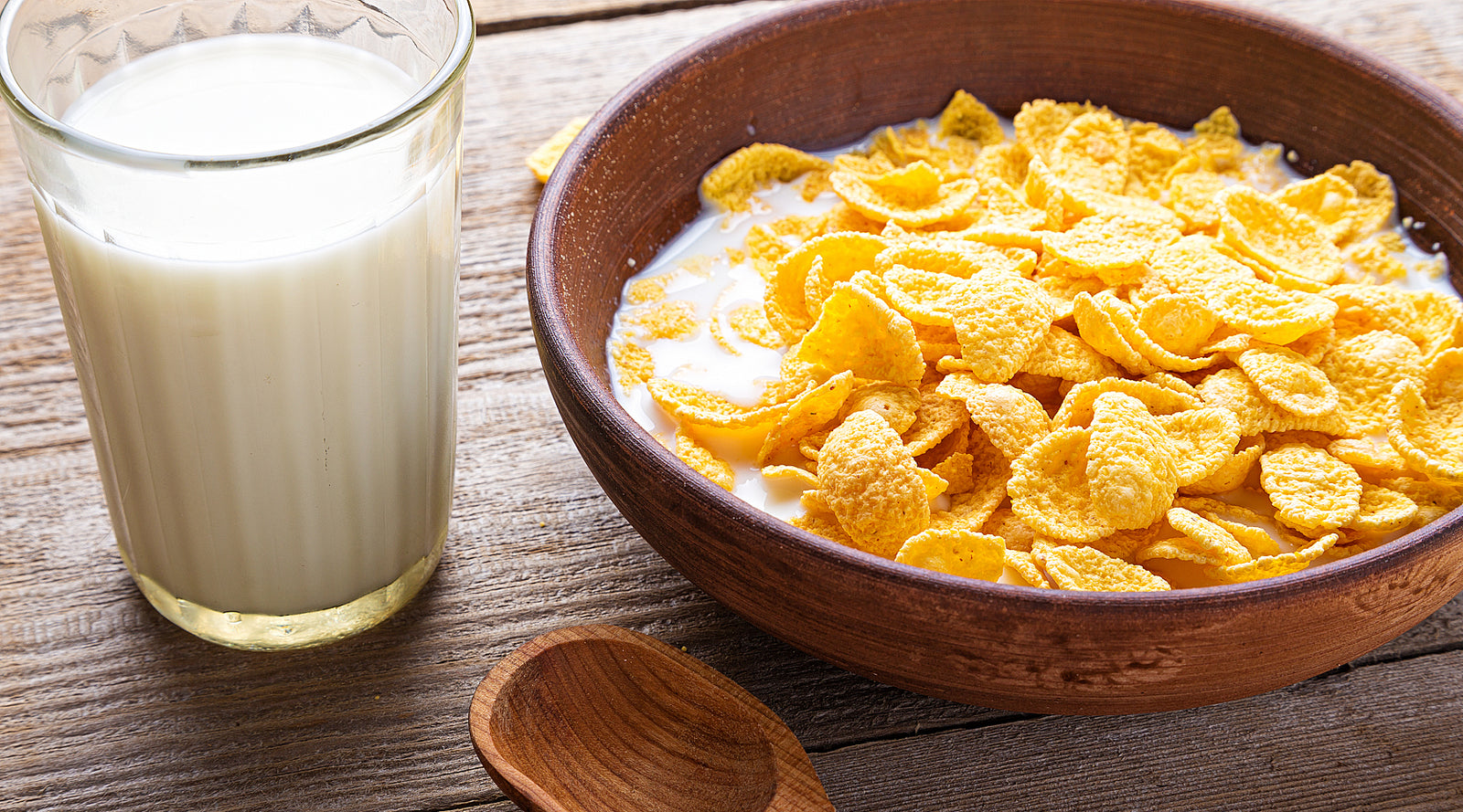 Oatmilk in a mason jar surrounded by oat flakes