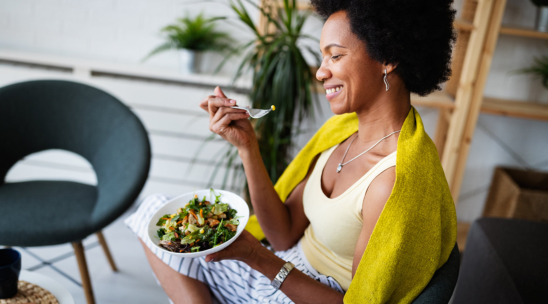 Person eating a salad in a bowl to regulate blood sugar.