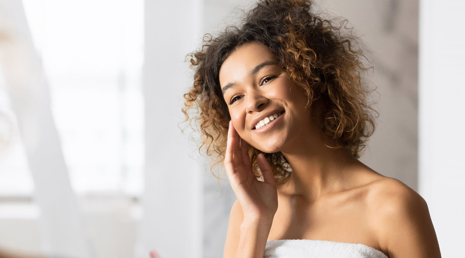 Woman smiles in bathroom mirror