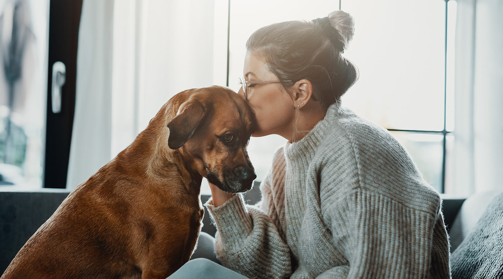 Smiling young woman sitting on a couch with a cup of coffee