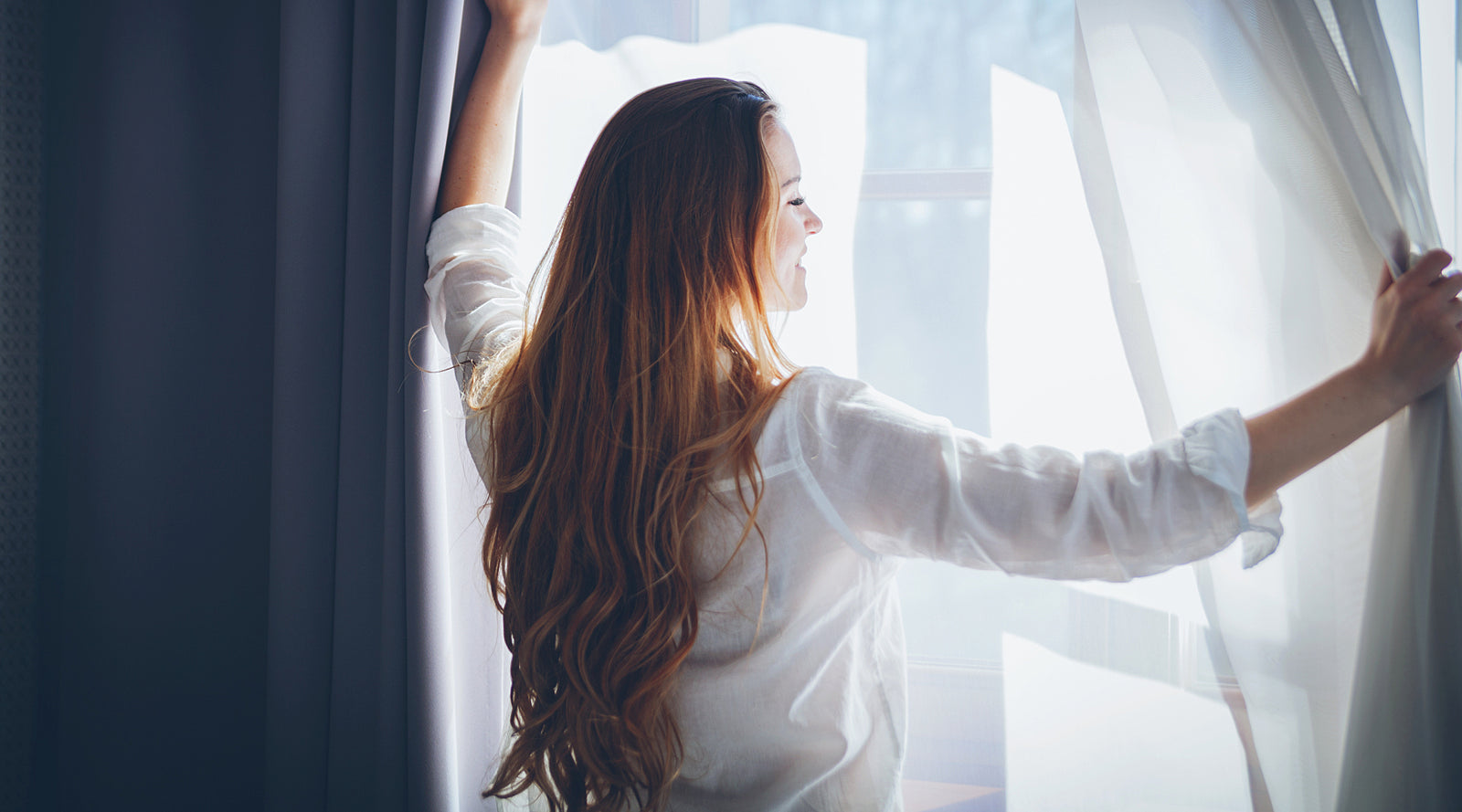 Woman with closed eyes holding a mug and sitting on a couch